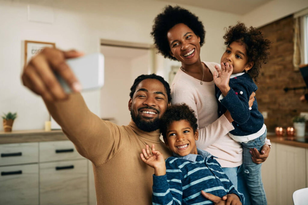 Happy Black Parents With Kids Making Video Call Smart Phone Home 1